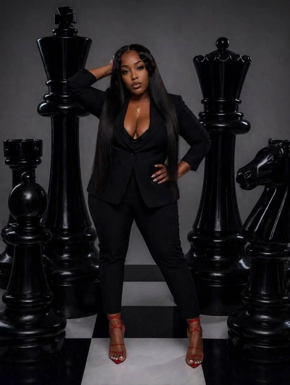 Jherice, founder of Wealth Frequency, in a black suit on a giant chessboard